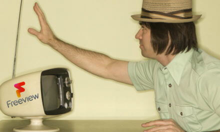 Man tuning an aerial on an old TV to get Freeview