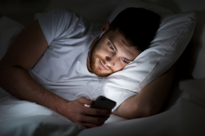 Man with a smartphone in bed