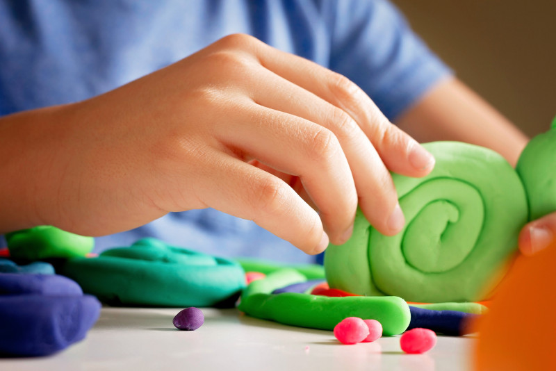 Hands playing modelling with clay