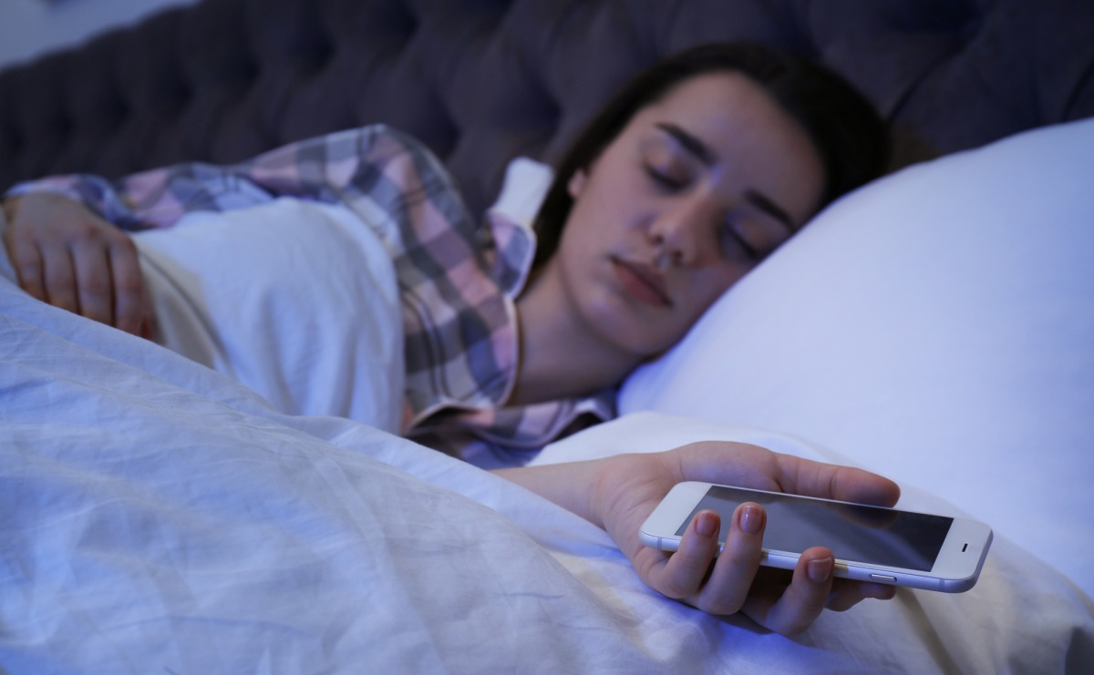 Woman sleeping with smartphone in bed 1200