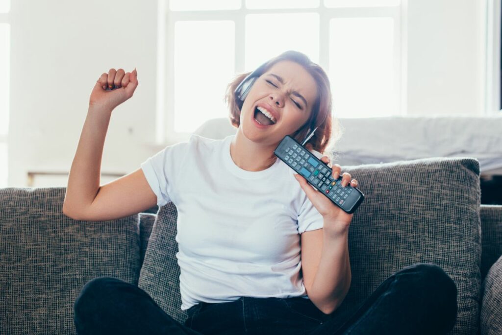 woman singing with TV remote 1200