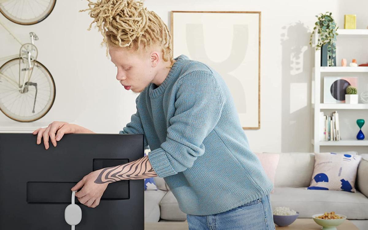 Chromecast With Google TV HD behind TV