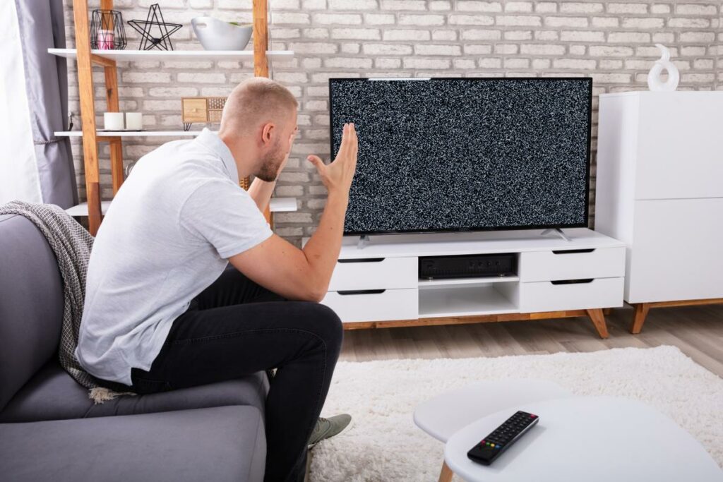 Angry man frustrated watching TV not working broken remote