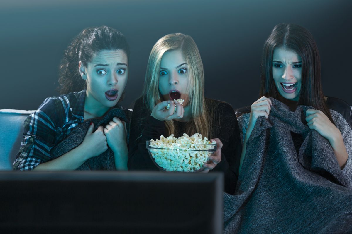 Girls watching a scary movie on TV