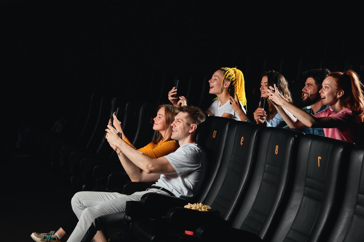 People filming with phone piracy cinema